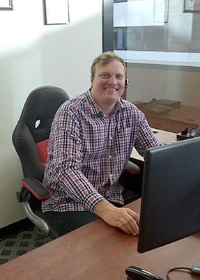 man smiling and sitting at the desk
